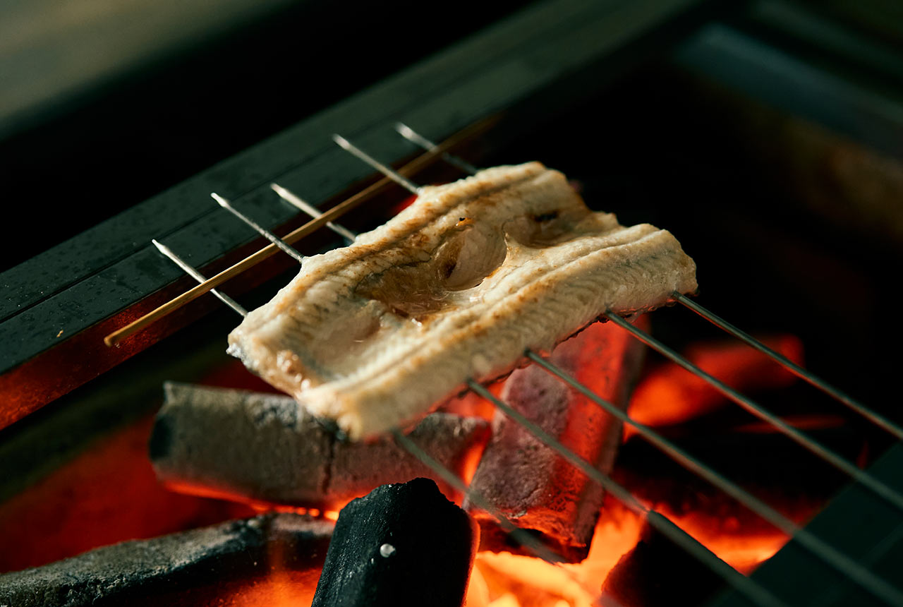 炭火で鰻を白焼きにしている