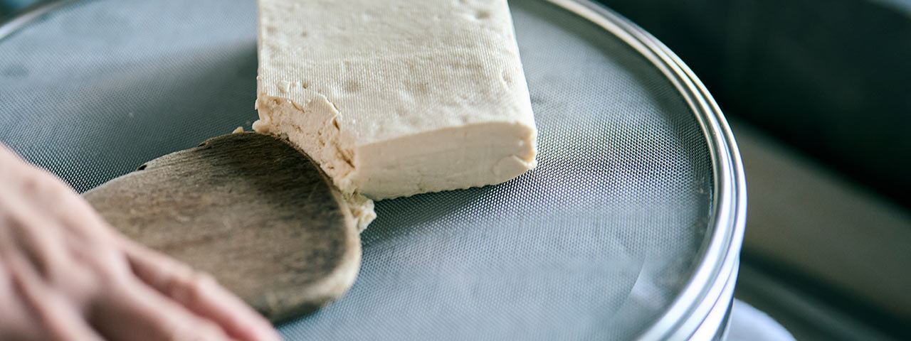 豆腐を裏ごししている