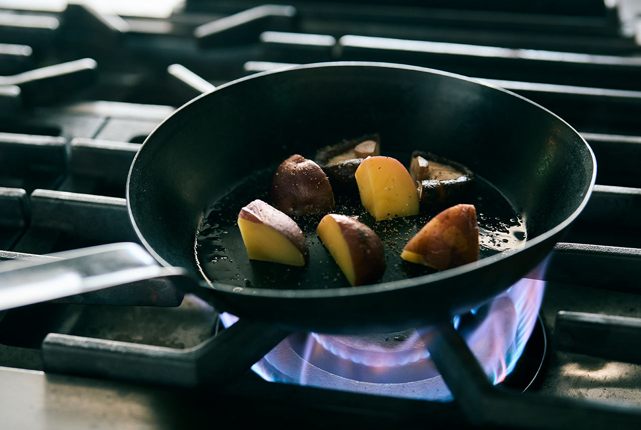 じゃがいもとしいたけをフライパンで焼いている