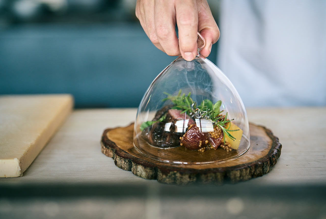 ガラスのドームで蓋をされたリブロースの炭火焼き