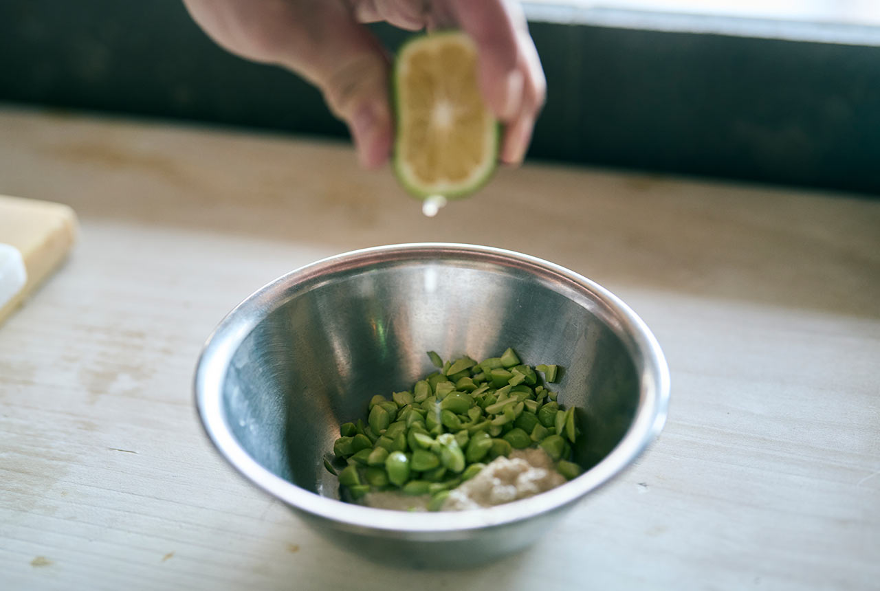 材料が入ったボウルにかぼすを絞っている