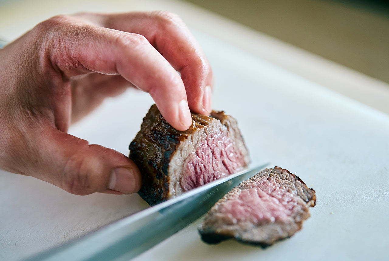 焼きあがった肉を切り分けている