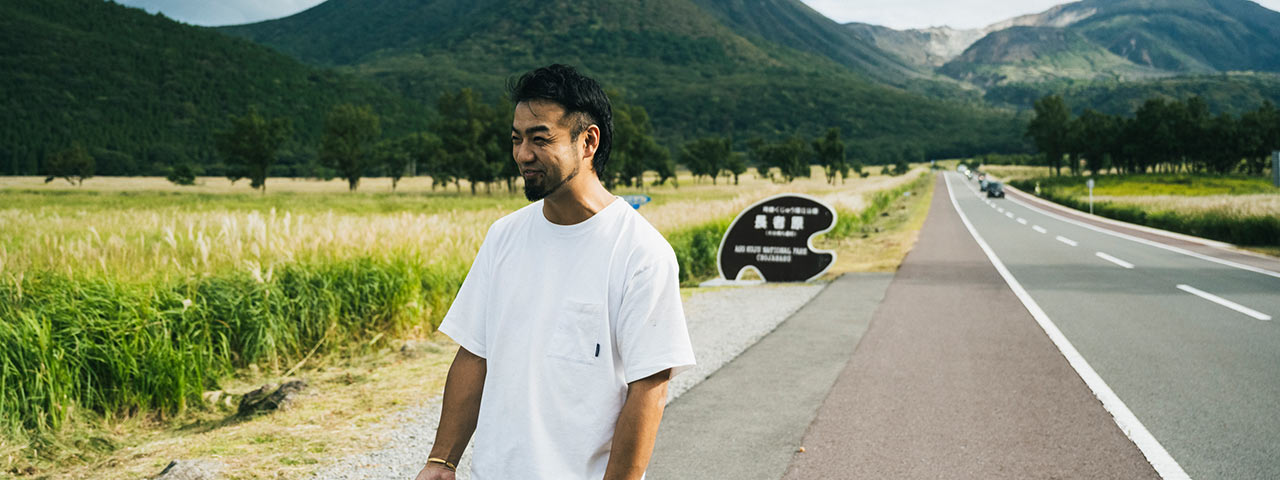 阿蘇くじゅう国立公園を背にした桑島さん