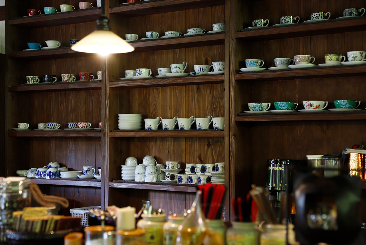 壁にさまざまなコーヒーカップがディスプレイされている