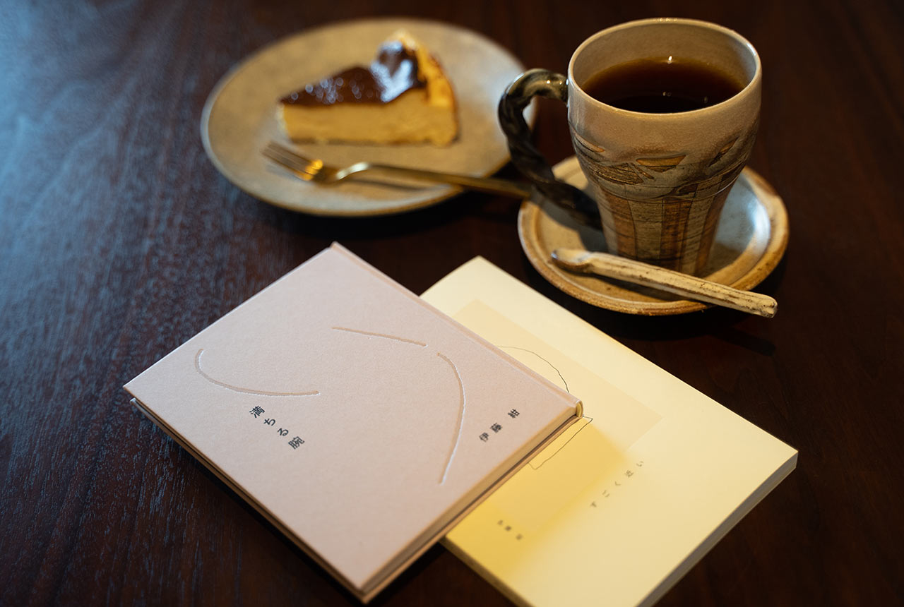 テーブルに置かれた2冊の本と、コーヒーとケーキ