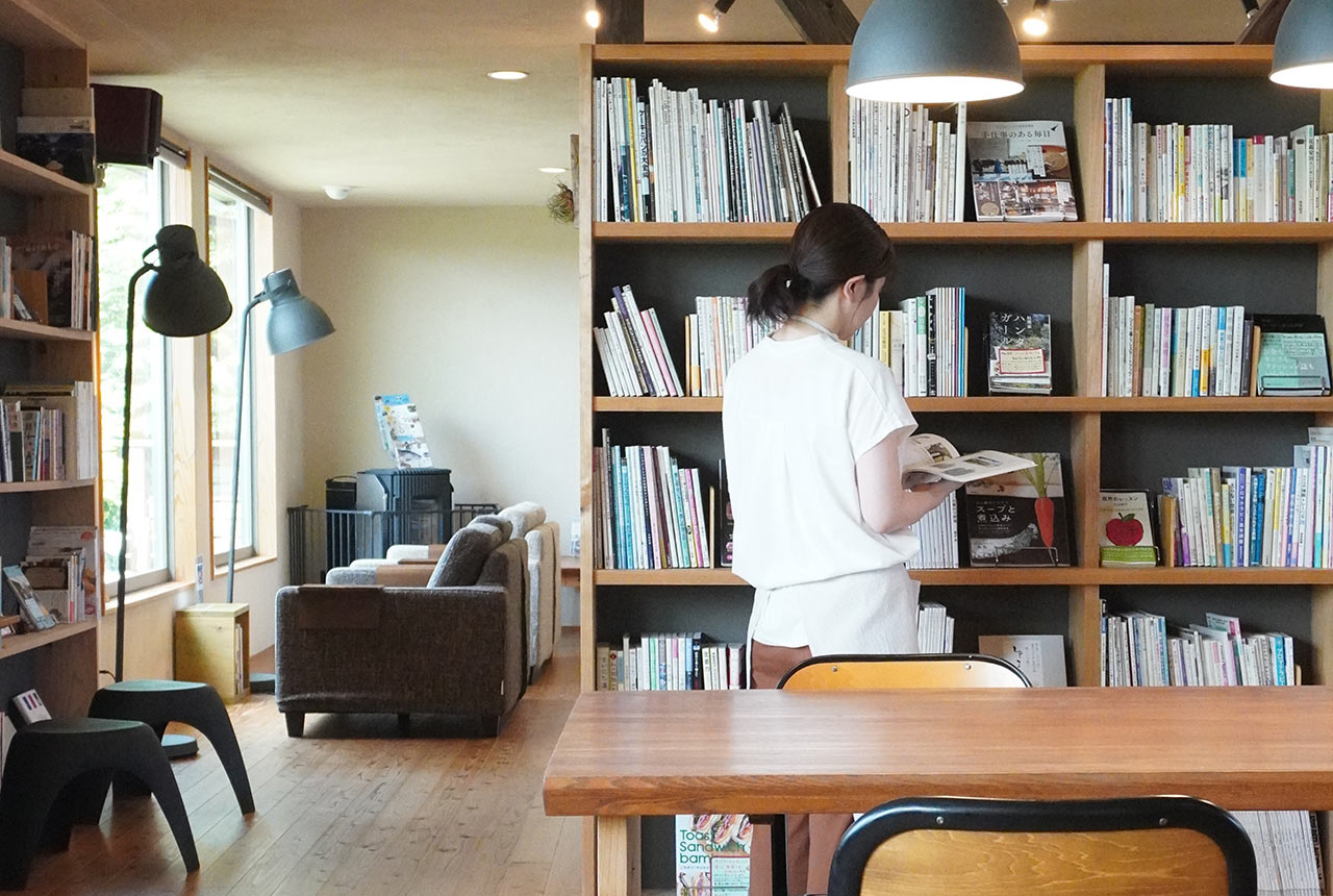 〈Book Cafe くらぼ〉店内で雑誌を読んでいる女性