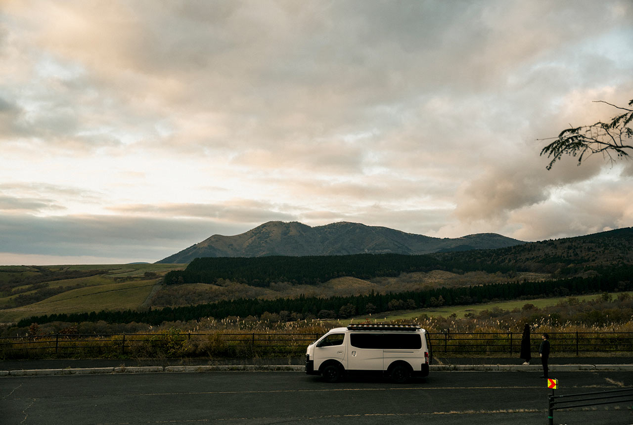 雄大な風景を背景にレンタルバンが走る様子