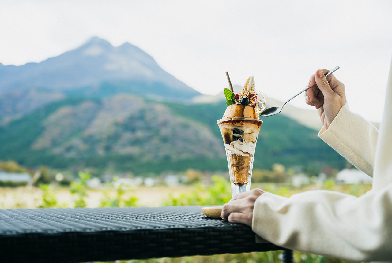 由布岳を背景に、パフェを食べる様子