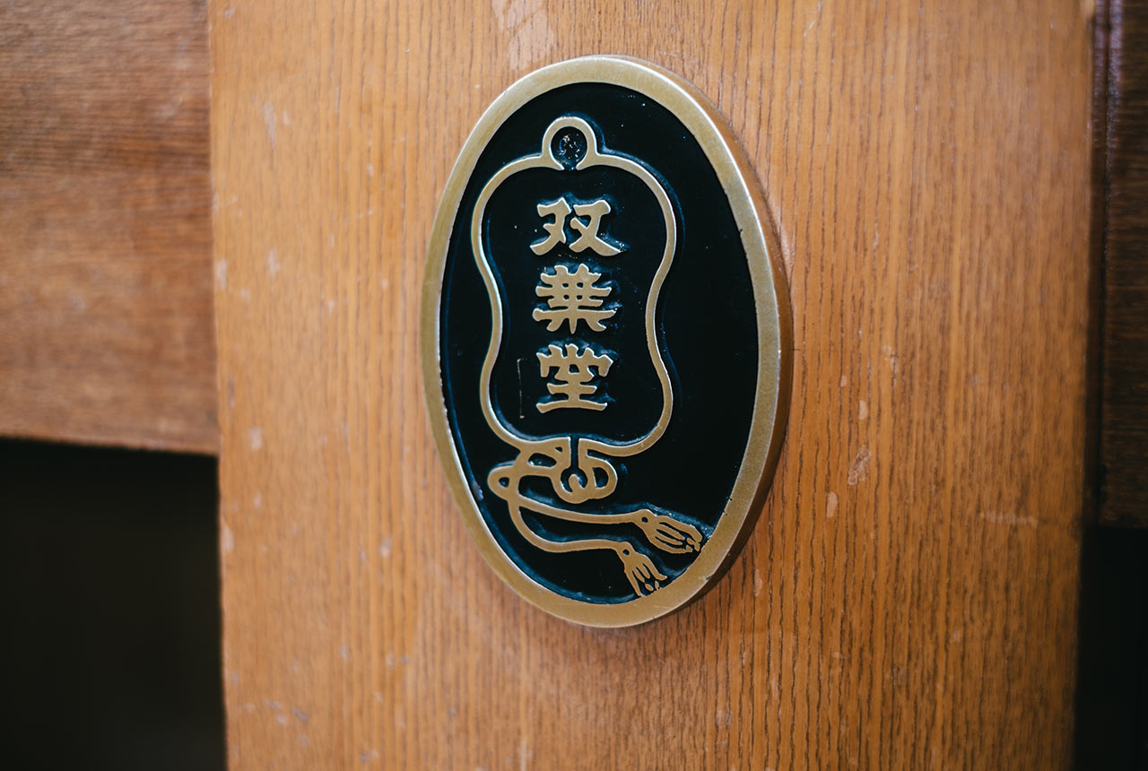 柱に設置された双葉堂の鉄銘板