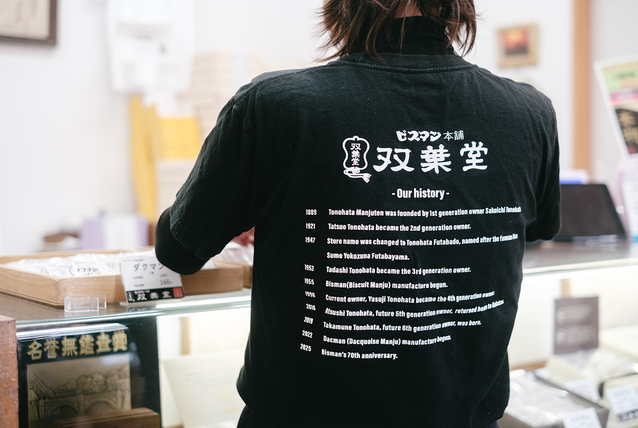 英語で年表が書かれたTシャツのバックプリント