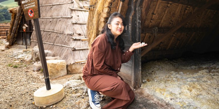 〈みょうばん湯の里〉で湯の花を手にする中島知子さん