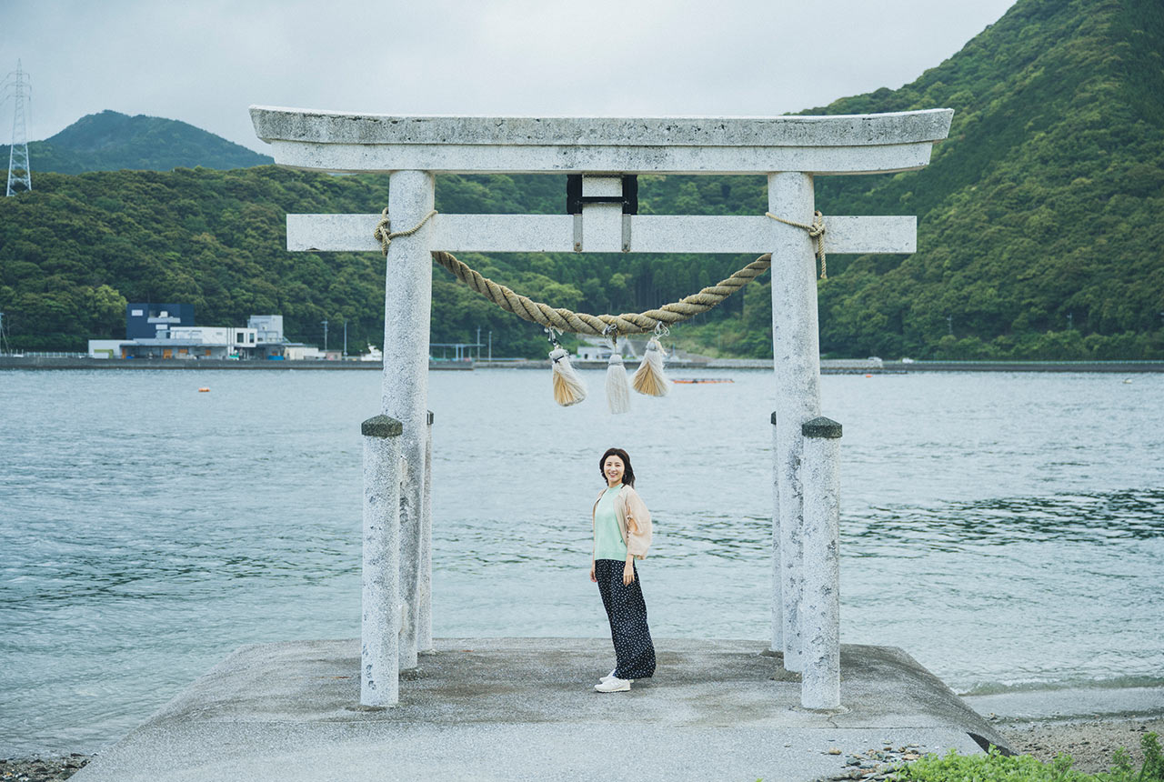 白い鳥居の下に立った宇賀なつみさん