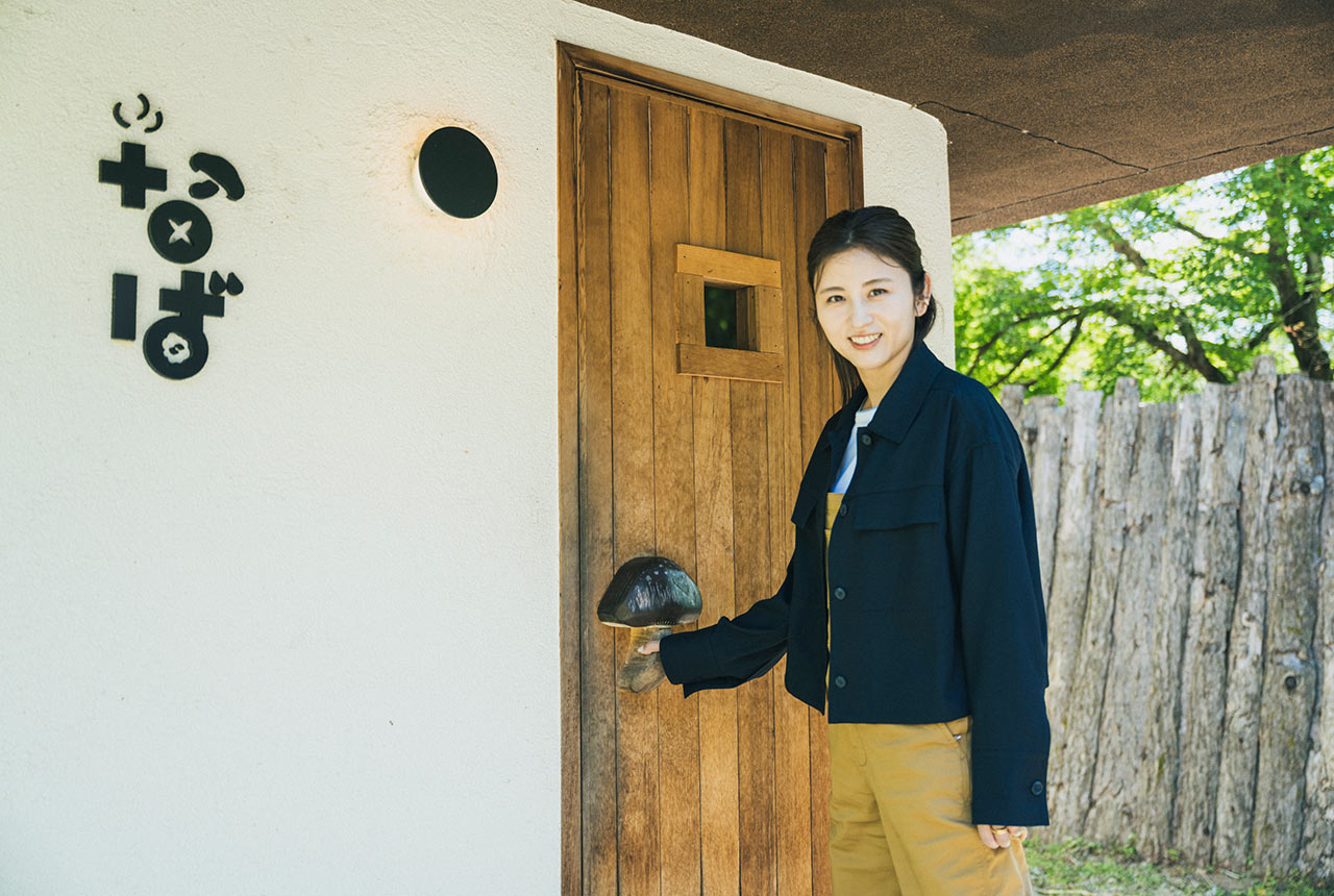 「なばサウナ」入口のドアノブをつかむ宇賀なつみさん