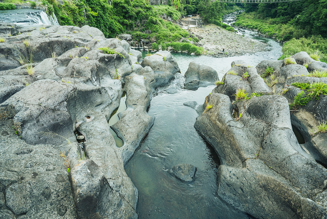滝の上側、うねるような岩の造形の中を水が流れている