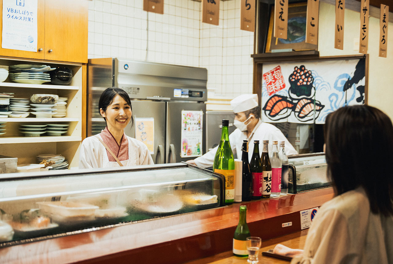 カウンターをはさんで宇賀なつみさんと2代目店主の戸髙秀世さんが談笑している