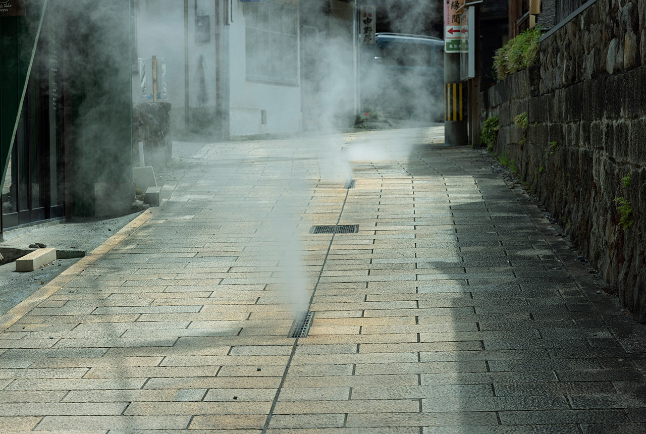 鉄輪温泉街の石畳から湯けむりがあがっている