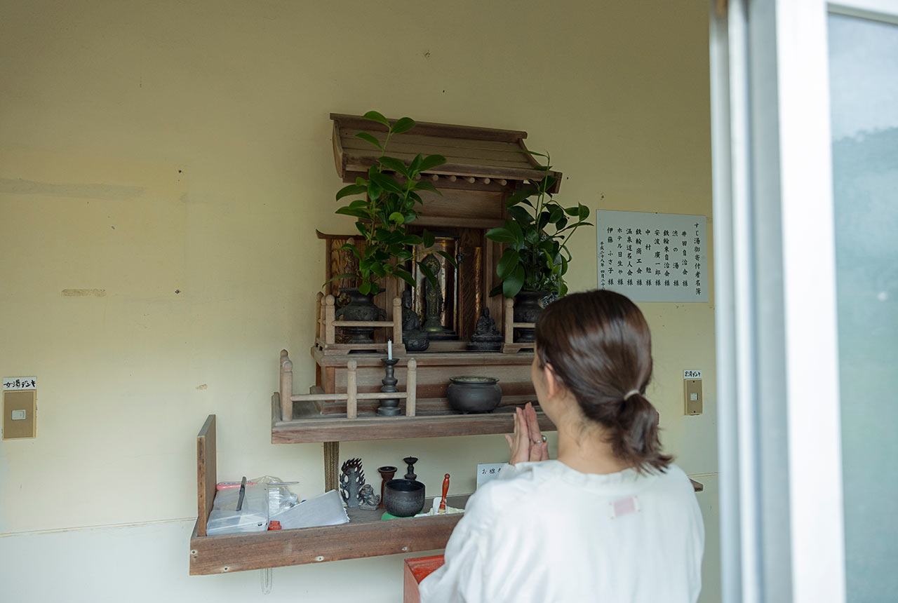 〈すじ湯〉入口の神棚にお参りする池田佳乃子さん