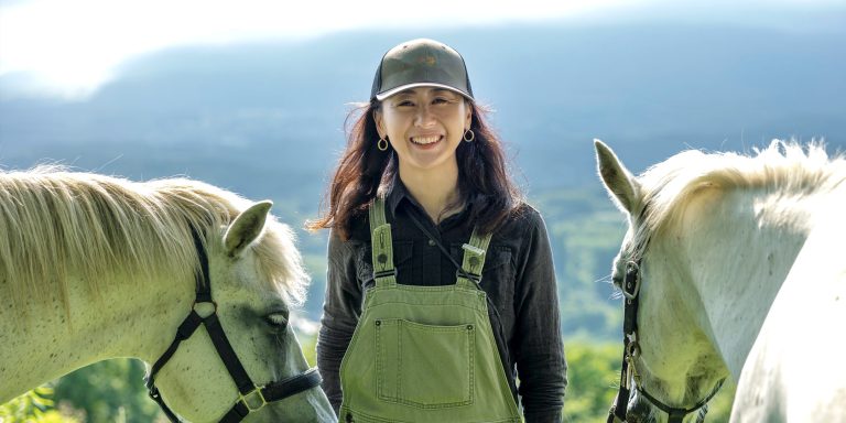 ２匹の白い馬に囲まれ笑顔の小笠原じゅんこさん